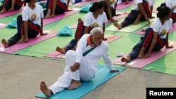 India's Prime Minister Narendra Modi participates in a yoga session to mark International Day of Yoga, in New Delhi, India, June 21, 2015. Modi led tens of thousands of people in the yoga session in the centre of the capital on Sunday to showcase the country's signature cultural export, which has prompted criticism of fomenting social divisions at home. 