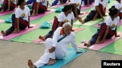 FILE - India's Prime Minister Narendra Modi participates in a yoga session to mark International Day of Yoga, in New Delhi, India, June 21, 2015. In an effort to promote India's traditions abroad, two yoga teachers from India will hold daily classes at the upcoming World Economic Forum at Davos.