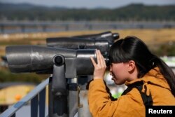 FILE - A Chinese tourist looks towards the north through a pair of binoculars at the Imjingak pavilion near the demilitarized zone which separates the two Koreas.