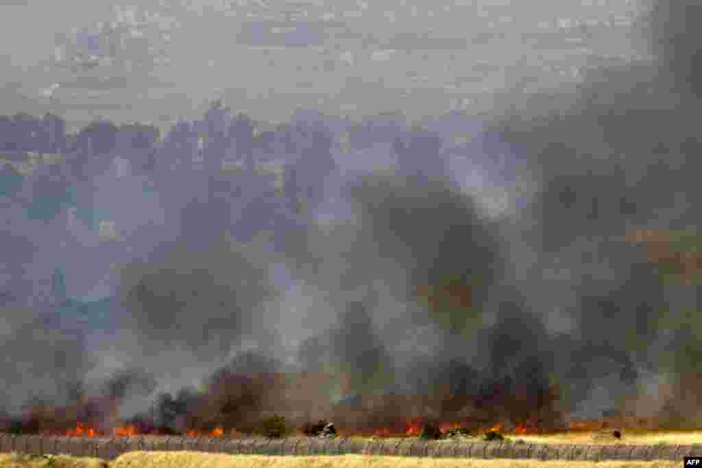 In this picture taken from the Israeli side along the Israel-Syria ceasefire line in the Golan Heights shows smoke billowing from a fire caused by clashes between Syrian rebels and forces loyal to the regime near the Quneitra crossing.
