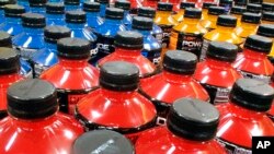 FILE - Sodas and energy drinks line the shelves in a grocery store in Springfield, Illinois, May 18, 2016. The World Health Organization recommends countries use tax policy to increase the price of sugary drinks as a way to fight obesity and diabetes.