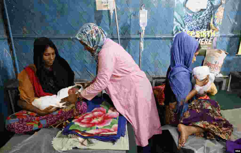 Midwife Mitu Akhter (C) helps Hamida with her newborn as Yasmin Ara (R) prepares to nurse her son Mar. 31, 2019. The two babies were born just hours earlier in the Gonoshathaya Kendra clinic at Kutupalong refugee camps. (Hai Do/VOA)