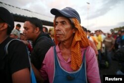 A Central American migrant, part of a caravan trying to reach the U.S., waits on the bridge that connects Mexico and Guatemala to cross into Mexico to continue his trip, in Ciudad Hidalgo, Mexico, Oct. 22, 2018.