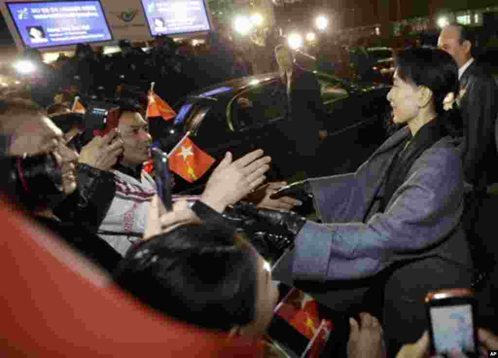 Myanmar's opposition leader Aung San Suu Kyi, right, is greeted by Myanmarese who live in South Korea upon her arrival at Incheon International Airport in Incheon, west of Seoul, South Korea, Monday, Jan. 28, 2013.