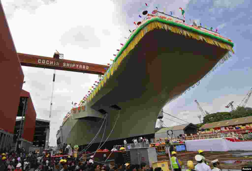 Para karyawan Cochin Shipyard berdiri di dekat Pembawa Pesawat India P-71 &#39;Vikrant&#39; yang dibangun untuk Angkatan Laut India saat peluncuran di kota India selatan Kochi, India. 