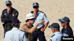 FILE - A man argues with police before being detained for an alcohol-related incident on North Cronulla Beach in Sydney, December 18, 2005.