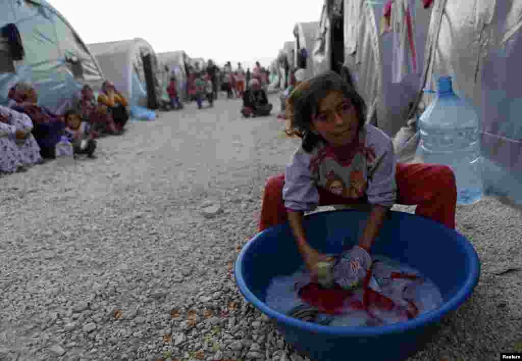 A Kurdish refugee girl from the Syrian town of Kobani washes in front of their family tent in a camp in the southeastern town of Suruc, Sanliurfa province. The U.S. military conducted nine airstrikes against Islamic State militants in Syria during the past two days, including seven strikes near the border town of Kobani. 