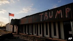 Un mensaje que dice "Ayúdanos Trump" fue escrito en un negocio dañado por le huracán Michael en Callaway, Florida, el domingo 14 de octubre de 2018.
