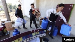 Syrian refugees receive aid at a distribution center in Bar Elias village in Bekaa Valley.