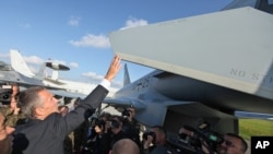 New NATO Secretary General Jens Stoltenberg of Norway touches the wing of an aircraft during his visit to the 32 Tactical Air Base in Lask, Poland, Oct 6, 2014. 
