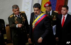 FILE - Venezuela's President Nicolas Maduro, center, stands with his Defense Minister Vladimir Padrino Lopez before giving his annual address Jan. 14, 2019