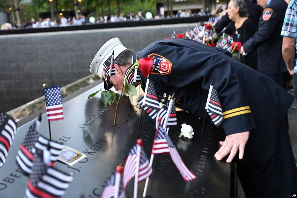 Retired Paramedic Chief Charlie Wells kisses the name of a relative killed in the attack on the World Trade Center at the National September 11 Memorial in New York on the 20th anniversary of the attacks, Sept. 11, 2021.