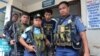 Polisi Filipina bersenjata mengawal warga negara Indonesia eks sandera Abu Sayyaf, Muhamad Sofyan (tengah) ketika meninggalkan rumah sakit di kota Jolo, Provinsi Sulu, pulau Mindanao, Filipina selatan tahun 2016 (foto: ilustrasi). 