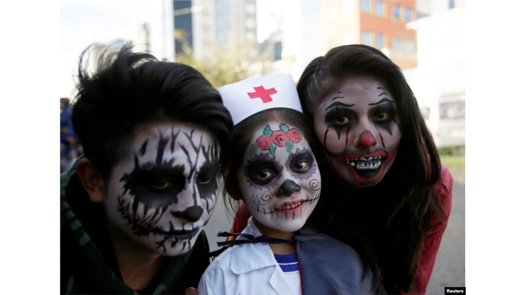 Orang-orang yang mengenakan kostum berpose untuk foto selama perayaan Halloween di La Paz, Bolivia, 31 Oktober 2018. (Foto: Reuters / David Mercado)