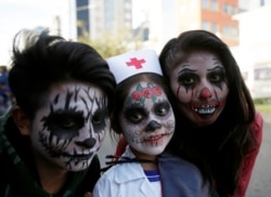 FILE - People in costume pose for a photograph during Halloween celebrations in La Paz, Bolivia, October 31, 2018. (REUTERS/David Mercado)
