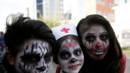 FILE - People in costume pose for a photograph during Halloween celebrations in La Paz, Bolivia, October 31, 2018. (REUTERS/David Mercado)