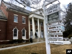 Signs hang outside Edmond Town Hall, a building that houses a community theater and offices, in Newtown, Conn., March 25, 2019. Jeremy Richman, father of Sandy Hook Elementary school shooting victim Avielle Richman, was found dead Monday at the building where he had an office.
