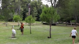 A visitor takes a photograph of a pelican at Divjaka-Karavasta Lagoon, western Albania, Tuesday, June 22, 2021.