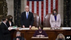 Vice President Mike Pence and Speaker of the House Nancy Pelosi, D-Calif., read the final certification of Electoral College votes cast in November's presidential election during a joint session of Congress. (AP Photo/J. Scott Applewhite, Pool)