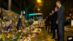 President Barack Obama (R) French President Francois Hollande (2-R), and Paris Mayor Anne Hidalgo pause for a moment of silence at the Bataclan concert hall just after midnight, Nov. 30, 2015, in Paris.