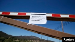 A sign is seen on the gate of a National Park Service site is closed in the Santa Monica mountains, Agoura Hills, California, October 1, 2013.