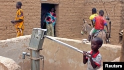 FILE - A child pumps water in the northern town of Kouroume, Mali, in May 2015. A UN envoy warns that the up to 41 million young people in the Sahel are at risk of radicalization.