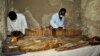 Des archéologues égyptiens examinent un sarcophage en bois découvert dans une tombe de l'ère pharaonique à Draa Abul Naga, près de Louxor, Egypte, le 18 avril 2017.