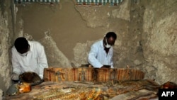 Members of an Egyptian archaeological team work on a wooden coffin discovered in a 3,500-year-old tomb in the Draa Abul Nagaa necropolis, near the southern Egyptian city of Luxor, April 18, 2017.