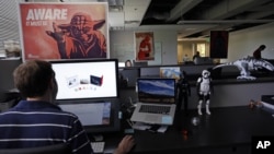 An employee at Sphero, a fast-growing toy robotics company, works surrounded by "Star Wars" toys and posters, at the company headquarters in Boulder, Colorado, July 24, 2015.