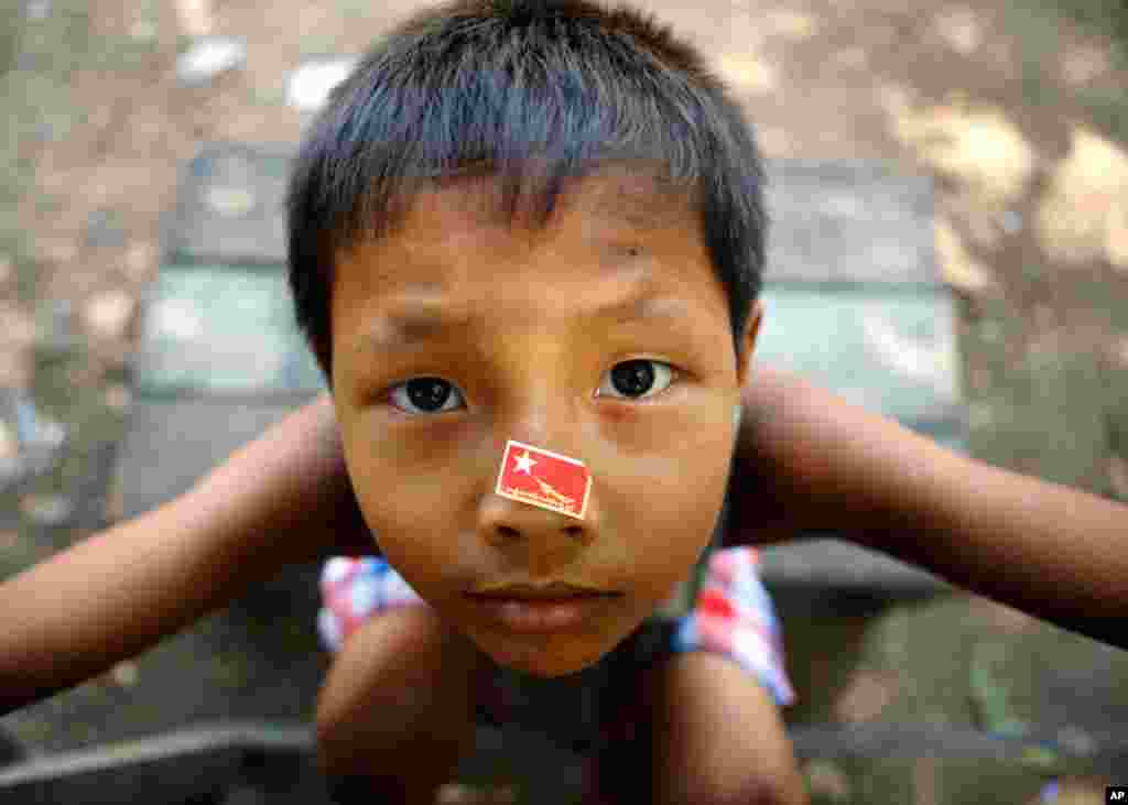A boy, with a sticker of party flag of National League for Democracy (NLD) in Rangoon, March 28, 2012. (Reuters)