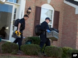 FILE - Prince William County, Va., officers collect evidence at a house in Woodbridge, Va., Feb. 29, 2016, following a fatal shooting at the residence during a domestic dispute.