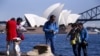 中国游客在澳大利亚悉尼港口以悉尼歌剧院为背景拍照留念。（2015年9月28日）