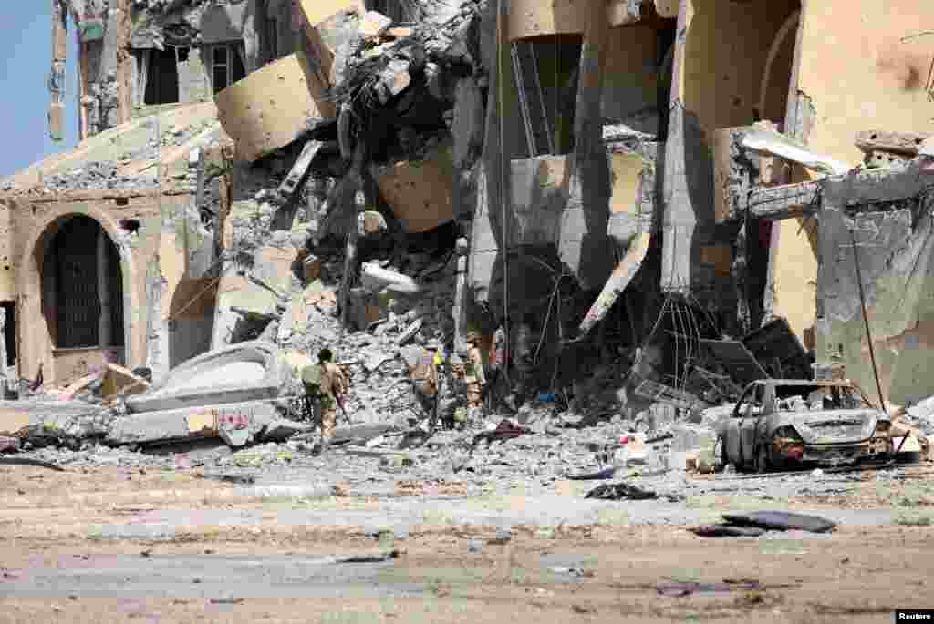 유엔의 지원을 받는 리비아 정부군 병력이 이슬람 수니파 무장조직 ISIL과의 전투로 파괴된 시르테의 건물 주변을 순찰하고 있다.