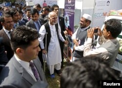 FILE - Afghan President Ashraf Ghani, center, talks to participants at an exhibition of Afghanistan products during the Regional Economic Cooperation Conference of Afghanistan (RECCA) in Kabul, Afghanistan, Sept. 4, 2015.