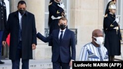 Le président français Emmanuel Macron (au centre) escorte le président nigérien Mohamed Bazoum (à gauche) alors que lui et le président burkinabè Roch Marc Christian Kabore (à droite) quittent le palais de l'Élysée à Paris le 12 novembre 2021.