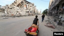 Palestinski dječak sa svojim bratom bježi iz kuće u Gazi nakon napada izraelske vojske