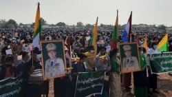 In this image provided by the Military True News Information Team, supporters of the military government hold nationalistic banners and portraits of Senior General Min Aung Hlaing, chairman of the State Administration Council, during a rally, Feb. 1, 2022 in Naypyitaw, Myanmar.