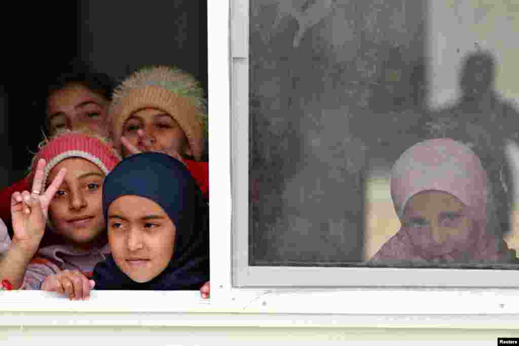 Syrian refugee children look out of their classroom window at Al- Zaatri refugee camp, in the Jordanian city of Mafraq, near the border with Syria, February 12, 2013. 
