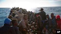 Les migrants subsahariens attendent dans un bateau de caoutchouc le secours de l'ONG Proactive Open Arms, en Méditerranée, à environ 22 milles au nord de Zumarah, Libye, 27 janvier 2017.. 