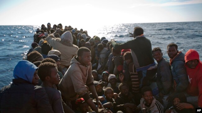 FILE - Migrants wait to be rescued by members of Proactive Open Arms NGO, in the Mediterranean sea, about 22 miles north of Zumarah, Libya, Jan. 27, 2017.