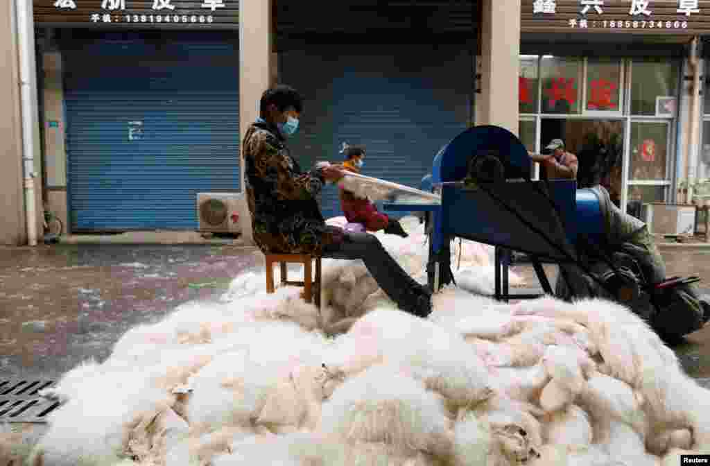 Workers use a machine to process fox fur at a market in Chongfu, Zhejiang province, China.