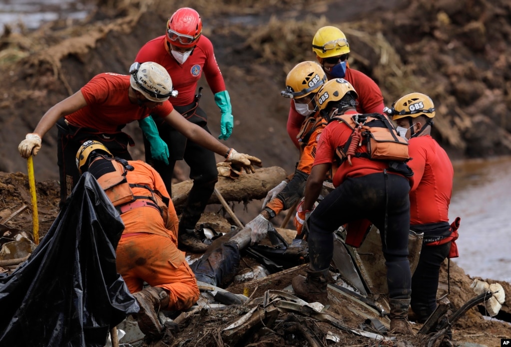 Firefighters pull a body from the mud days after a dam collapse in Brumadinho, Brazil. Firefighters carefully moved over dangerous mud in search of survivors or bodies.