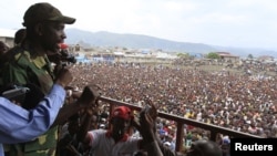The M23 rebels spokesman Vianney Kazarama (L) speaks to the crowd gathered at a stadium in Goma, Democratic Republic of Congo, November 21, 2012.