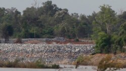 FILE - A fishing boat passes near a construction site of the Don Sahong dam, near the Cambodia-Laos border, June 20, 2016.