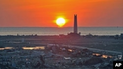 The New Year sunrise lights up an area devastated by the March 2011 tsunami in Kesennuma, Miyagi prefecture, January 1, 2012.