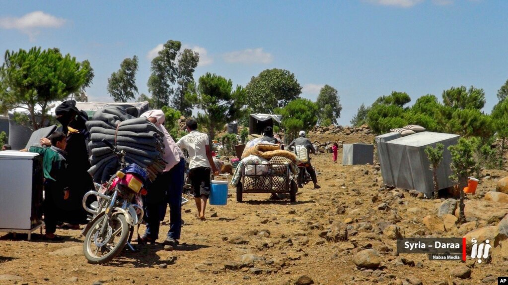 This July 5, 2018 photo provided by Nabaa Media, a Syrian opposition media outlet, shows people who fled from Daraa province, gathering in the Quneitra countryside, near the Israeli-occupied Golan Heights. 