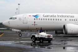 Seorang teknisi mengendarai mobil di dekat pesawat Garuda Indonesia Boeing 737 Max 8 yang diparkir di Garuda Maintenance Facility AeroAsia, di bandara Internasional Soekarno-Hatta, Tangerang, 13 Maret 2019. (REUTERS/Willy Kurniawan)