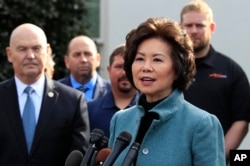 FILE - Transportation Secretary Elaine Chao, right, speaks to reporters outside the West Wing of the White House, March 4, 2019.