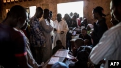 FILE - Voters on a constitutional referendum line up to collect their cards at a polling station in Bangui, Central African Republic, Dec. 2015. Elections for president and parliament are scheduled for Wednesday.
