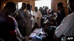 Voters queue to collect their cards at the polling station at the Koudoukou school in the flashpoint PK5 district in Bangui, Central African Republic, Dec.14, 2015.